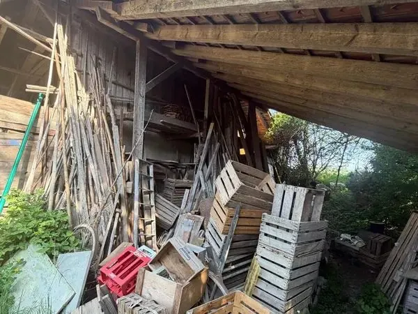 Remise encombrée de caisses en bois avant débarras