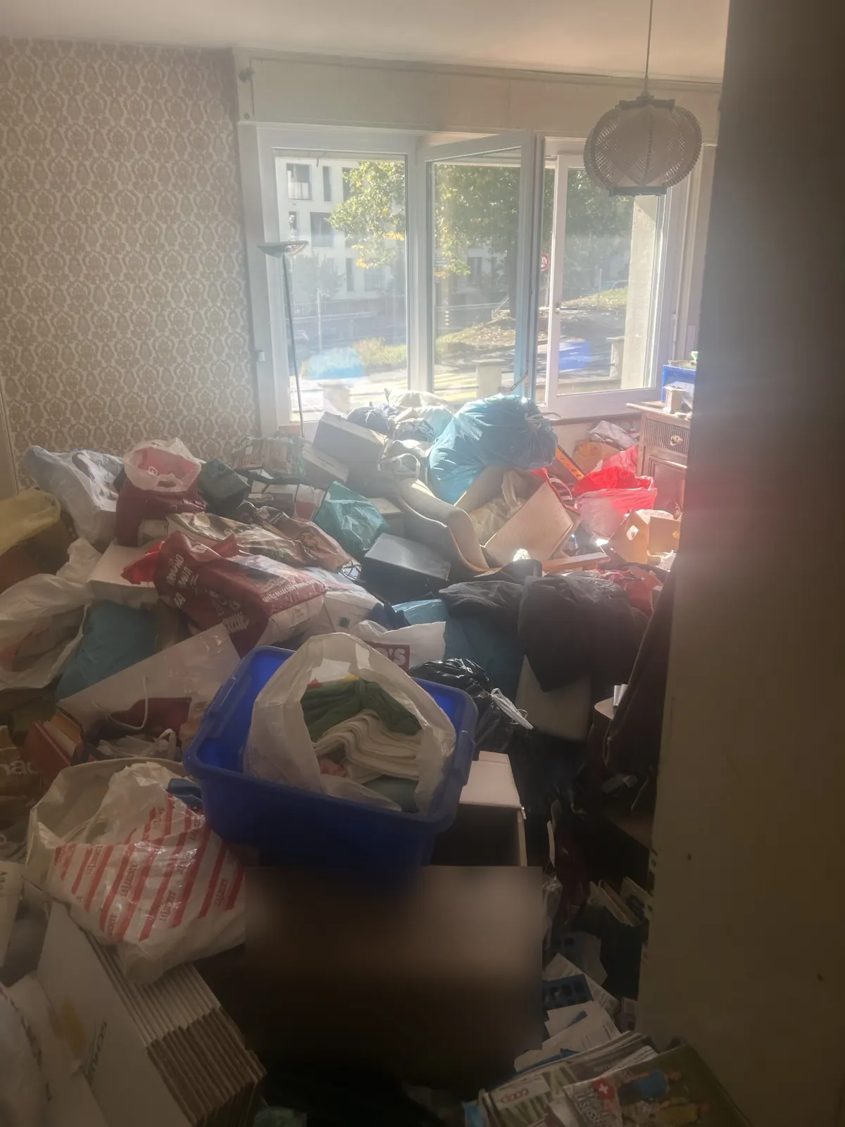 Appartement très encombré de sacs et cartons avant débarras et nettoyage à Fribourg
