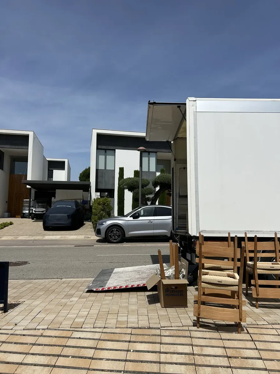 Camion de déménagement devant une villa, chaises prêtes au transport - Déménagement de villa à Fribourg