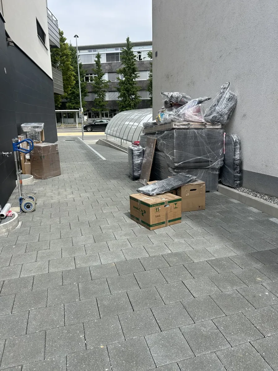 Cartons et mobilier emballés sur le trottoir, prêts pour un petit déménagement - Petit déménagement à Fribourg